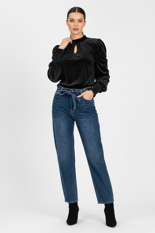 Модел с черна сатенена блуза и дънки