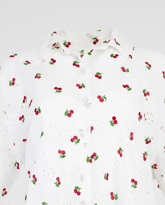 White 100% cotton Cherry Kiss summer shirt with short sleeves, delicate cherry print, and eyelet details.