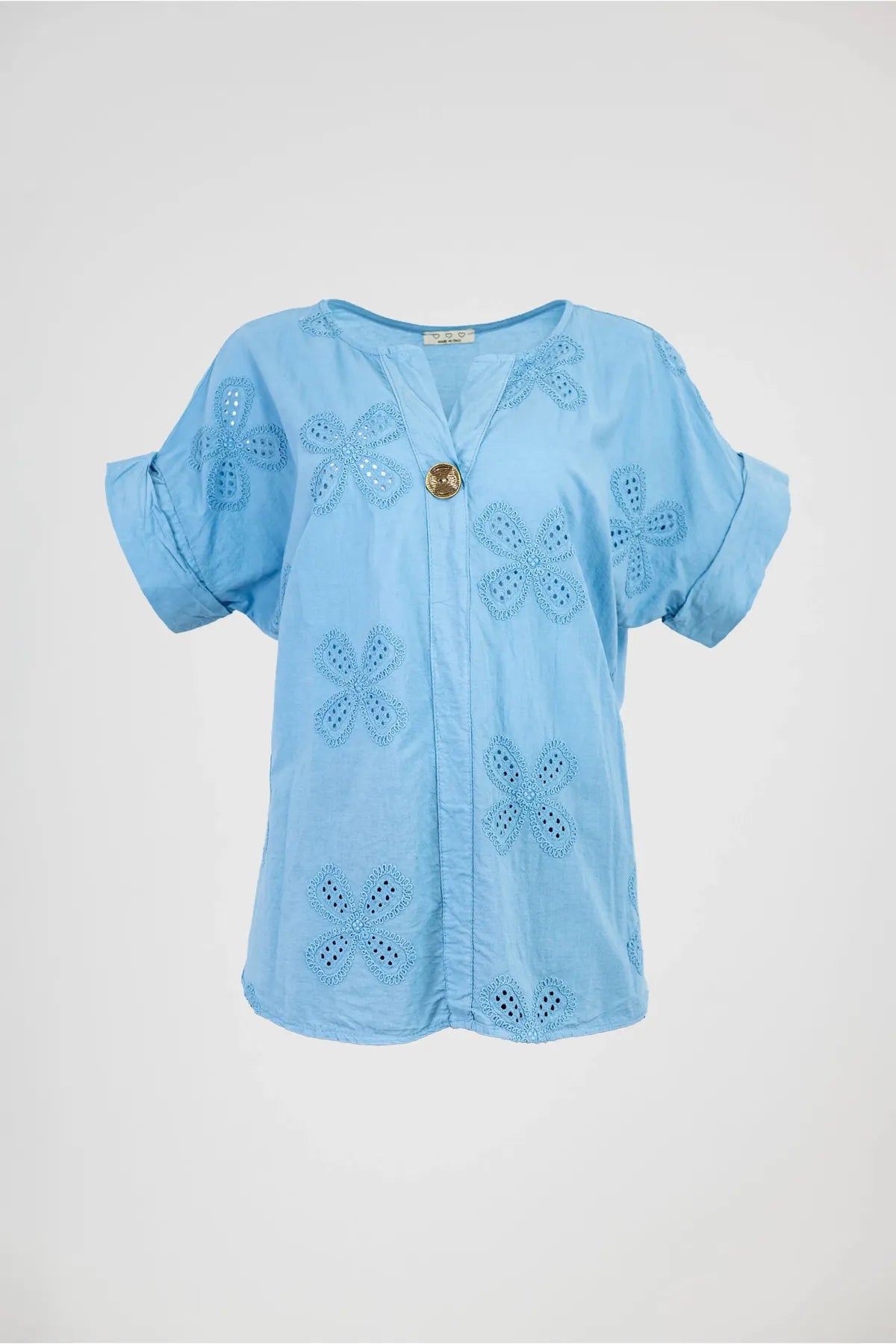 Light blue cotton Bloom Lace shirt with short sleeves, delicate floral embroidery, and a single gold button.
