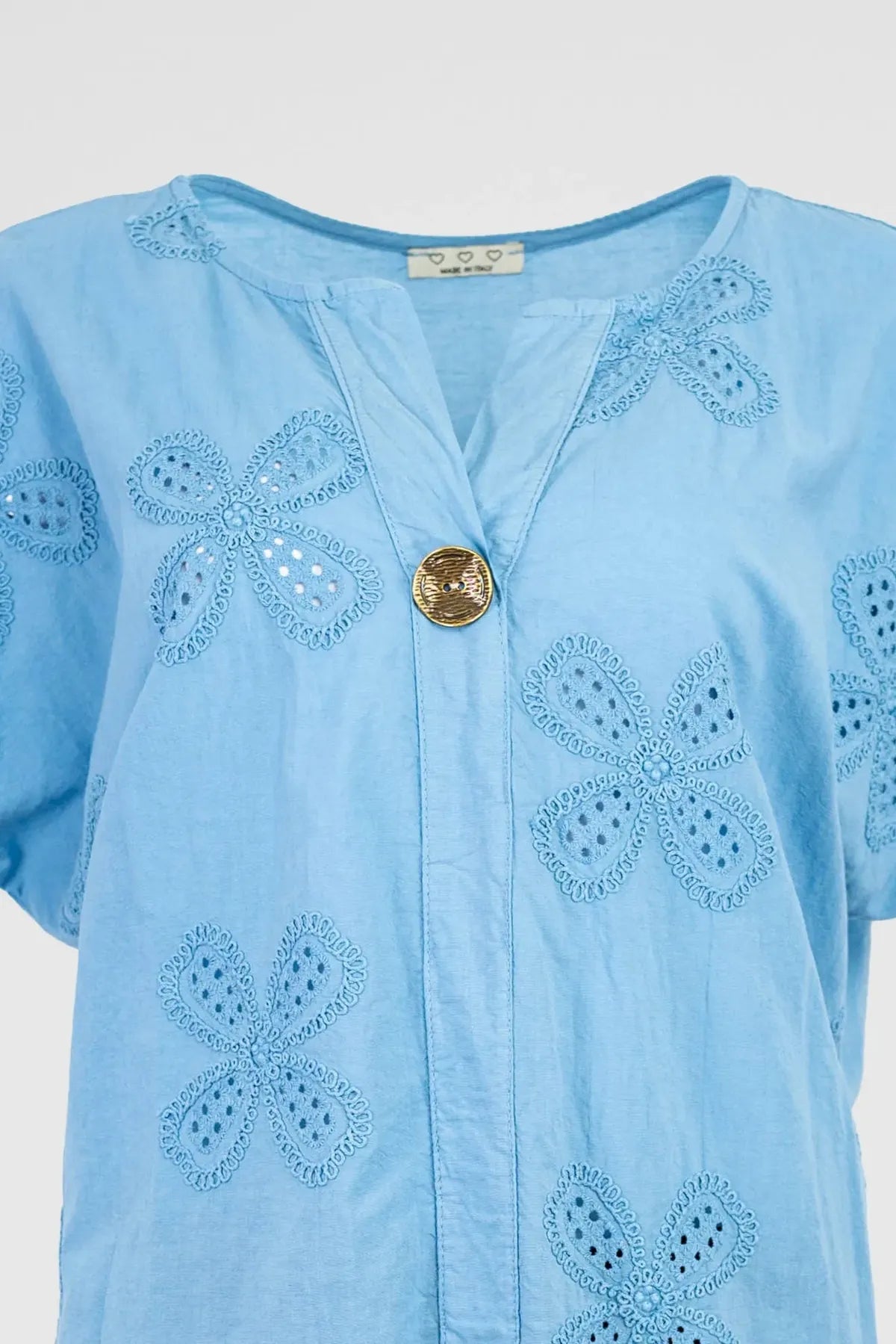 Light blue cotton Bloom Lace shirt with intricate floral eyelet embroidery and a single gold button.