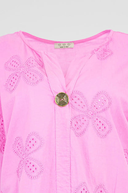Vibrant pink cotton Bloom Lace shirt with intricate floral eyelet embroidery and a stylish gold button V-neck.