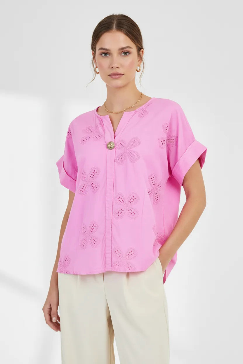 Model wears a vibrant pink Bloom Lace 100% cotton shirt with floral eyelet embroidery, V-neck, and rolled sleeves.