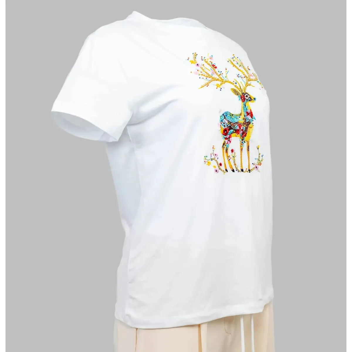 Stylish white women's t-shirt with vibrant, colorful embroidered deer and floral design.