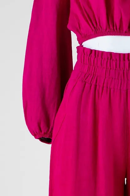 Vibrant fuchsia linen off-shoulder top with puff sleeves and high-waisted pants for a chic summer look.