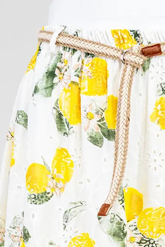 White cotton midi skirt with vibrant lemon print, delicate floral embroidery, and braided rope belt.