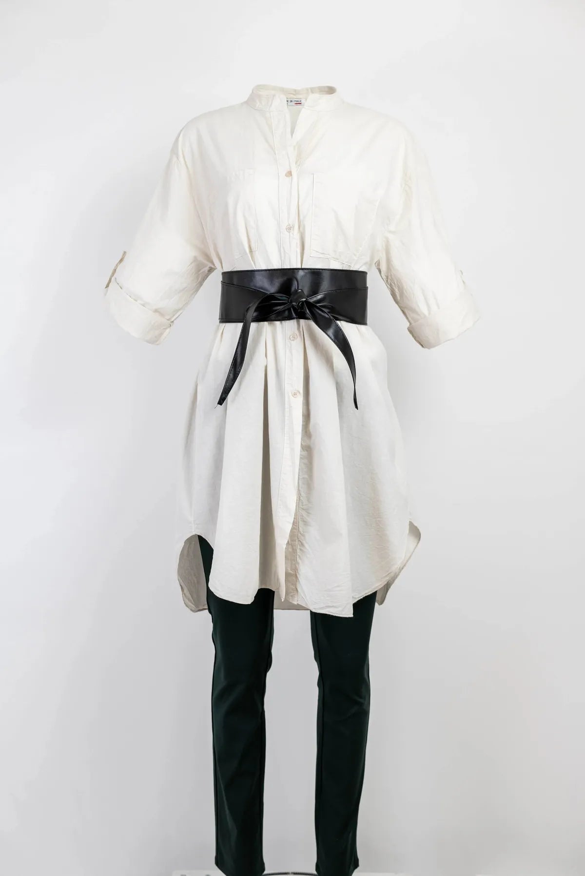 Stylish white 100% cotton long shirt/tunic with 3/4 sleeves, cinched by a black obi belt, paired with dark pants.