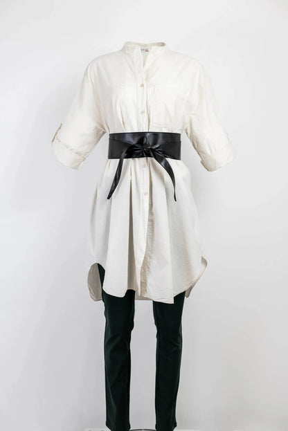 Stylish white 100% cotton long shirt/tunic with 3/4 sleeves, cinched by a black obi belt, paired with dark pants.