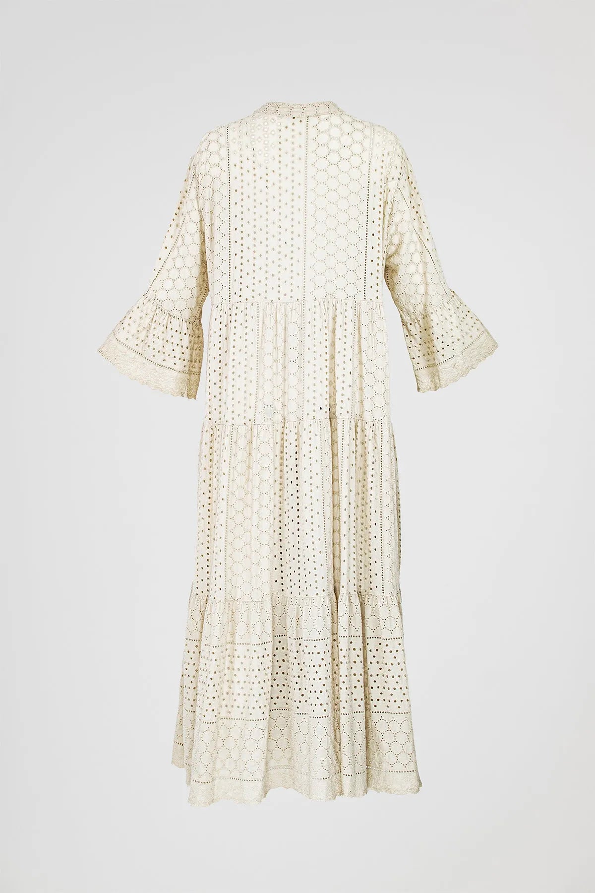 Elegant beige tiered boho maxi dress with intricate eyelet embroidery and flared sleeves.