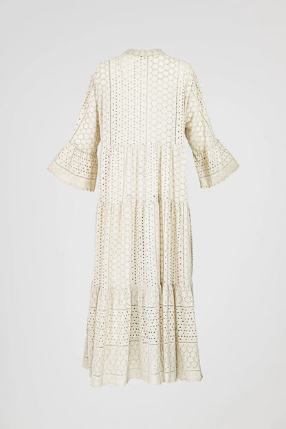 Elegant beige tiered boho maxi dress with intricate eyelet embroidery and flared sleeves.