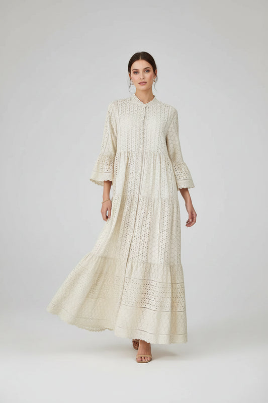 Elegant beige 100% cotton maxi dress with intricate eyelet embroidery, tiered skirt, and flared sleeves.