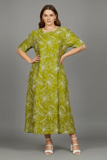 Chic plus-size Flora Flow dress in olive green with white floral print, loose fit, and short sleeves.