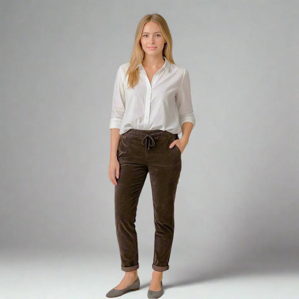 Дамски кафеви кадифени панталони, модерна кройка, съчетани с бяла риза, идеални за офис и ежедневие.