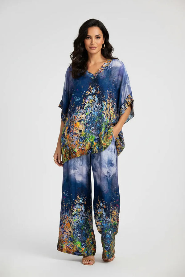 Дамски копринен сет Aurora Muse: топ с V-деколте и широк панталон с артистичен принт в синьо, зелено, жълто.