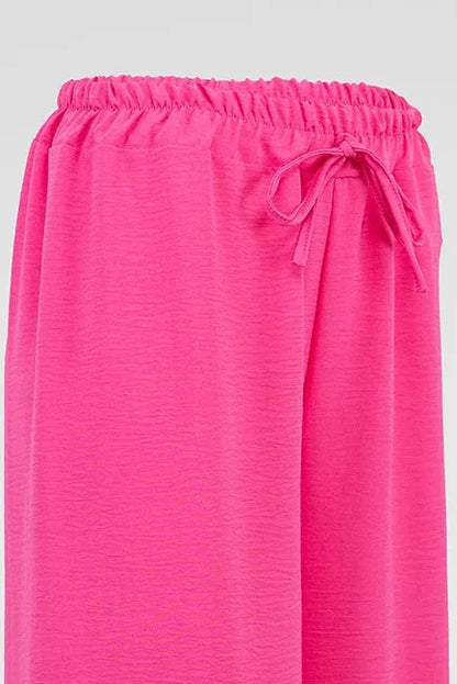 Vibrant pink women's summer pants with a comfortable elastic drawstring waist and flowing, wrinkle-resistant fabric.