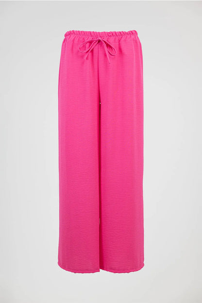 Vibrant pink wide-leg summer pants with an elastic drawstring waist, perfect for comfort and style.