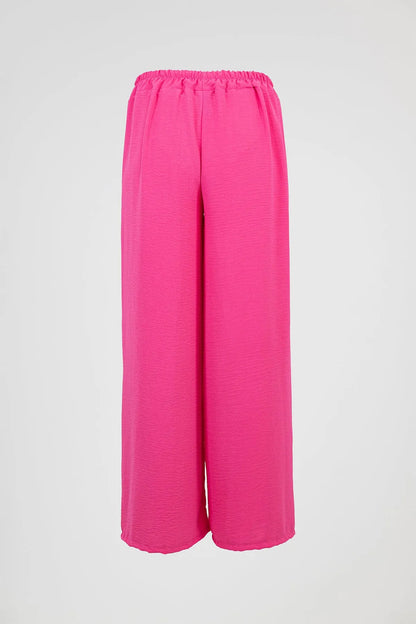 Vibrant pink wide-leg summer trousers with elastic waist, perfect for comfort and style.