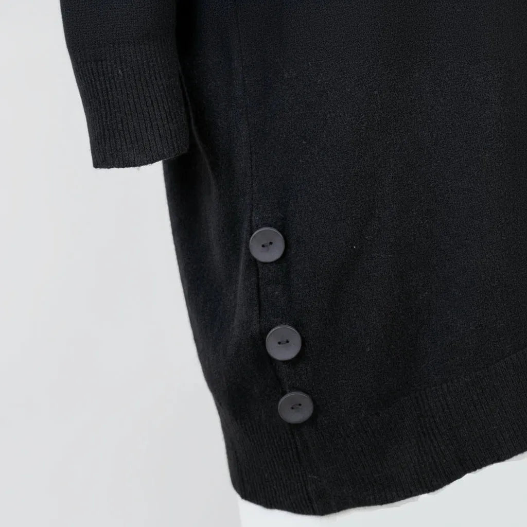 Детайл на дамски овърсайз пуловер с копчета в черно, удобен и стилен за колекция есен-зима.