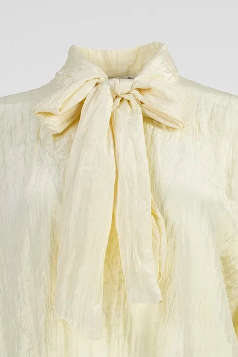 Елегантна блуза от 100% полиестер в цвят ванилия с панделка на яката.