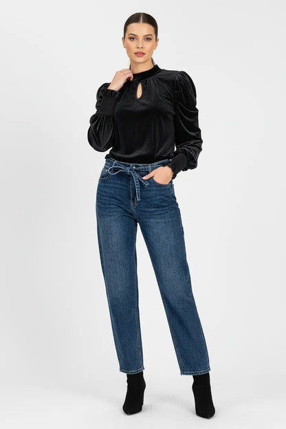 Стилен Velvet Denim Set: черна кадифена блуза с висока яка и деним дънки с връзка.